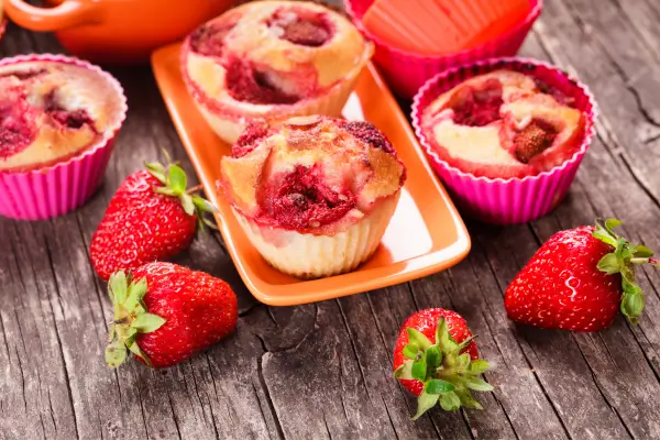 Muffins de frutas vermelhas dispostos em uma bandeja, opção saborosa e nutritiva para o lanche infantil, com ingredientes naturais e atrativos para as crianças.