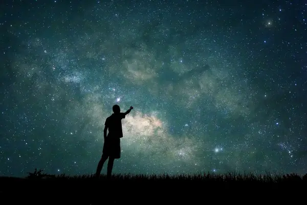 Criança observando o céu à noite com encanto, explorando as estrelas e despertando a imaginação em uma atividade de conexão com o universo e a natureza.