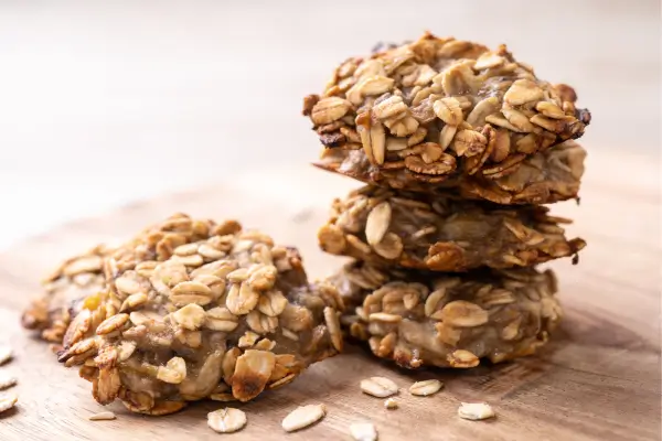 Biscoitos caseiros de banana e aveia sobre uma mesa rústica, prontos para serem servidos enquanto se conta uma história em família.