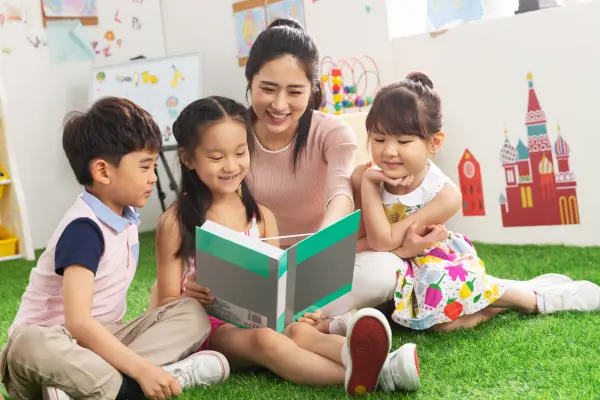 Contação de histórias ao ar livre: mãe lê para os filhos em um cenário natural.